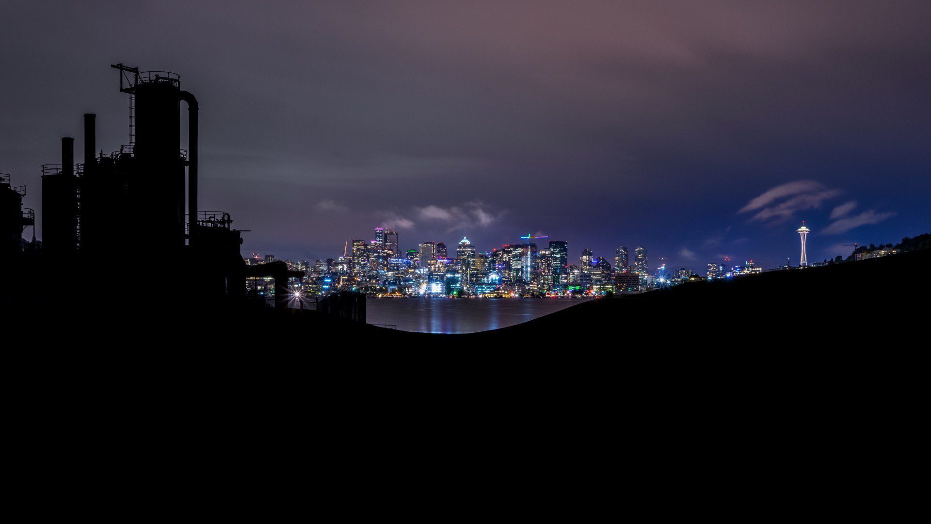 A city skyline at night with lights and buildings.