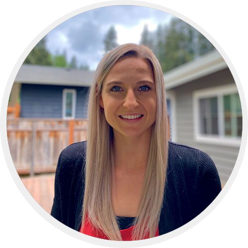 A woman standing in front of a house.