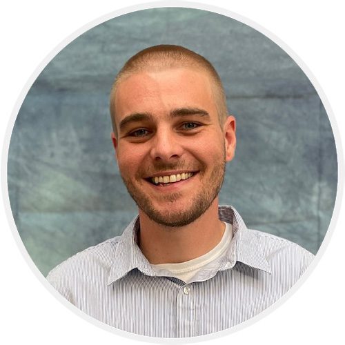 A man with a shaved head smiling for the camera.